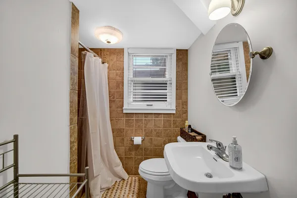 a bathroom with a sink a toilet and a mirror