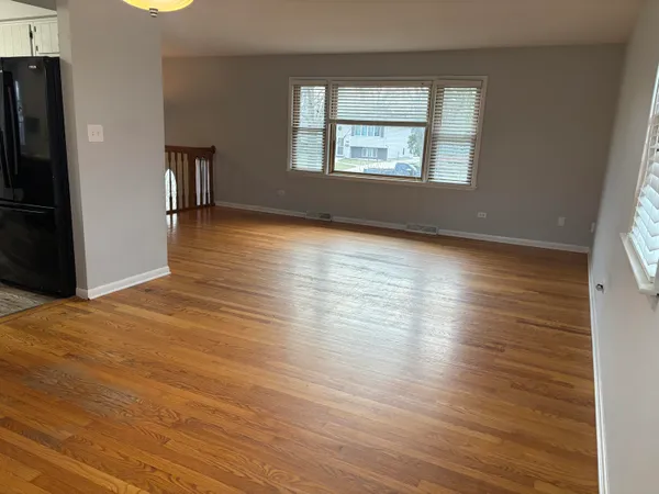 an empty room with wooden floor and a window