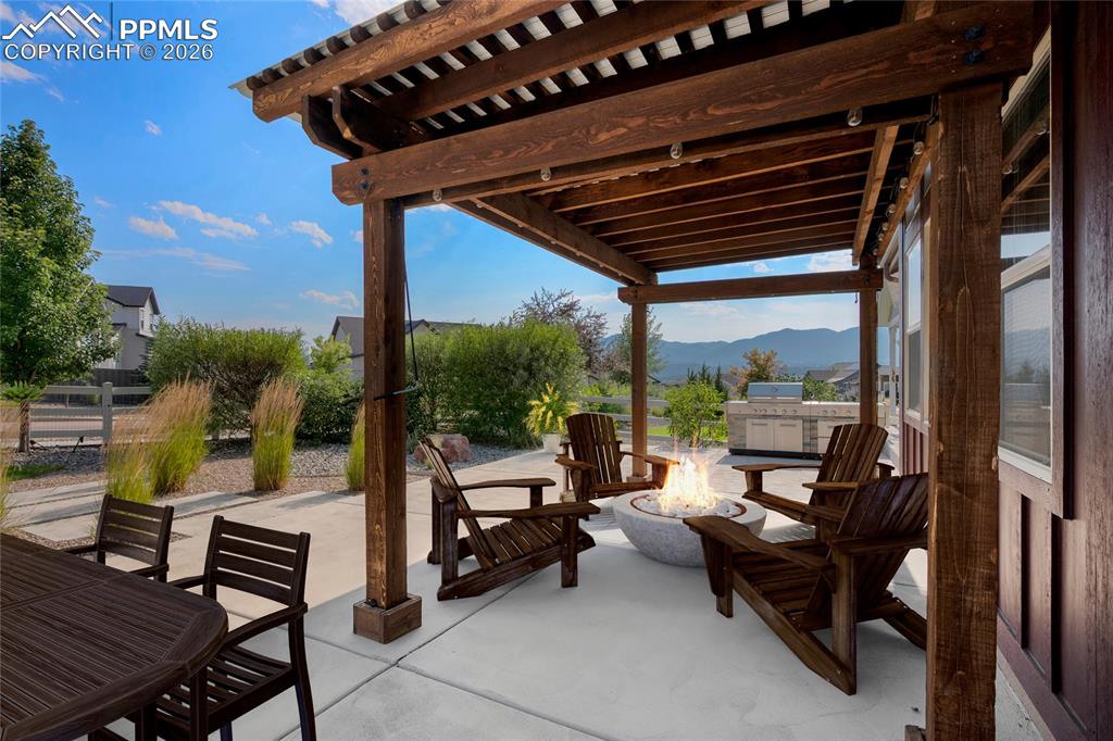 1073 Native Dancer Terrace Colorado Springs, CO 80921 - Photo 2 of 48 View of patio with a pergola, an outdoor fire pit, a mountain view, and grilling area