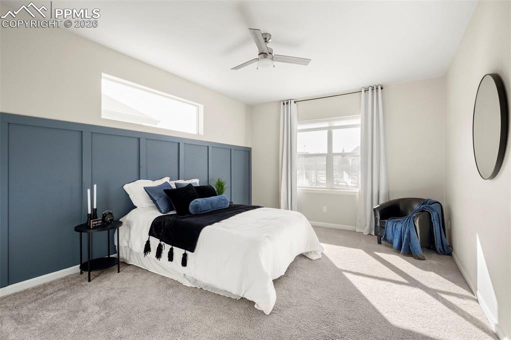 1073 Native Dancer Terrace Colorado Springs, CO 80921 - Photo 23 of 48 Bedroom featuring a decorative wall, a ceiling fan, and light colored carpet