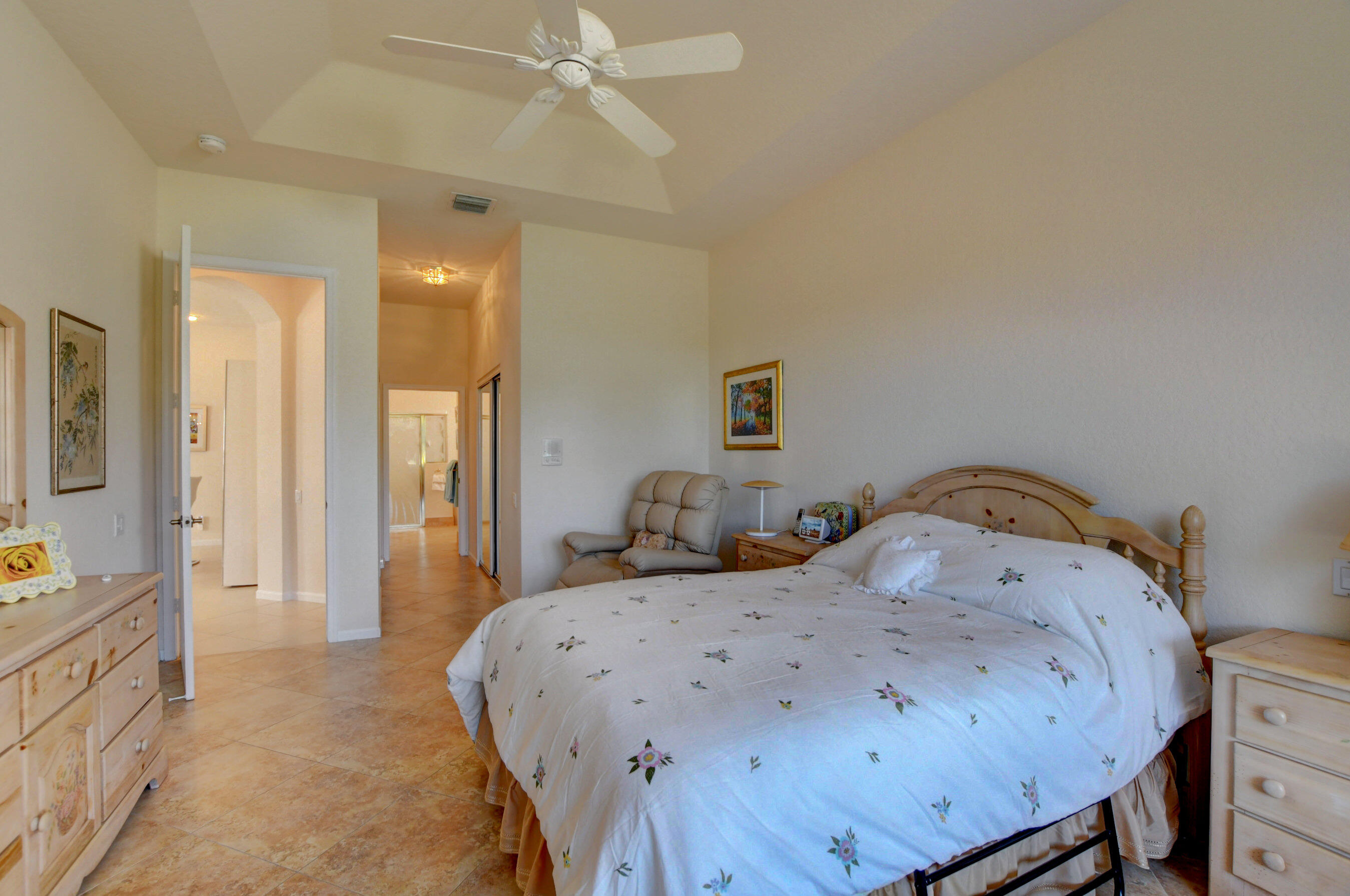 7097 Haviland Circle Boynton Beach, FL 33437 - Photo 15 of 72 a bedroom with a bed and a chandelier