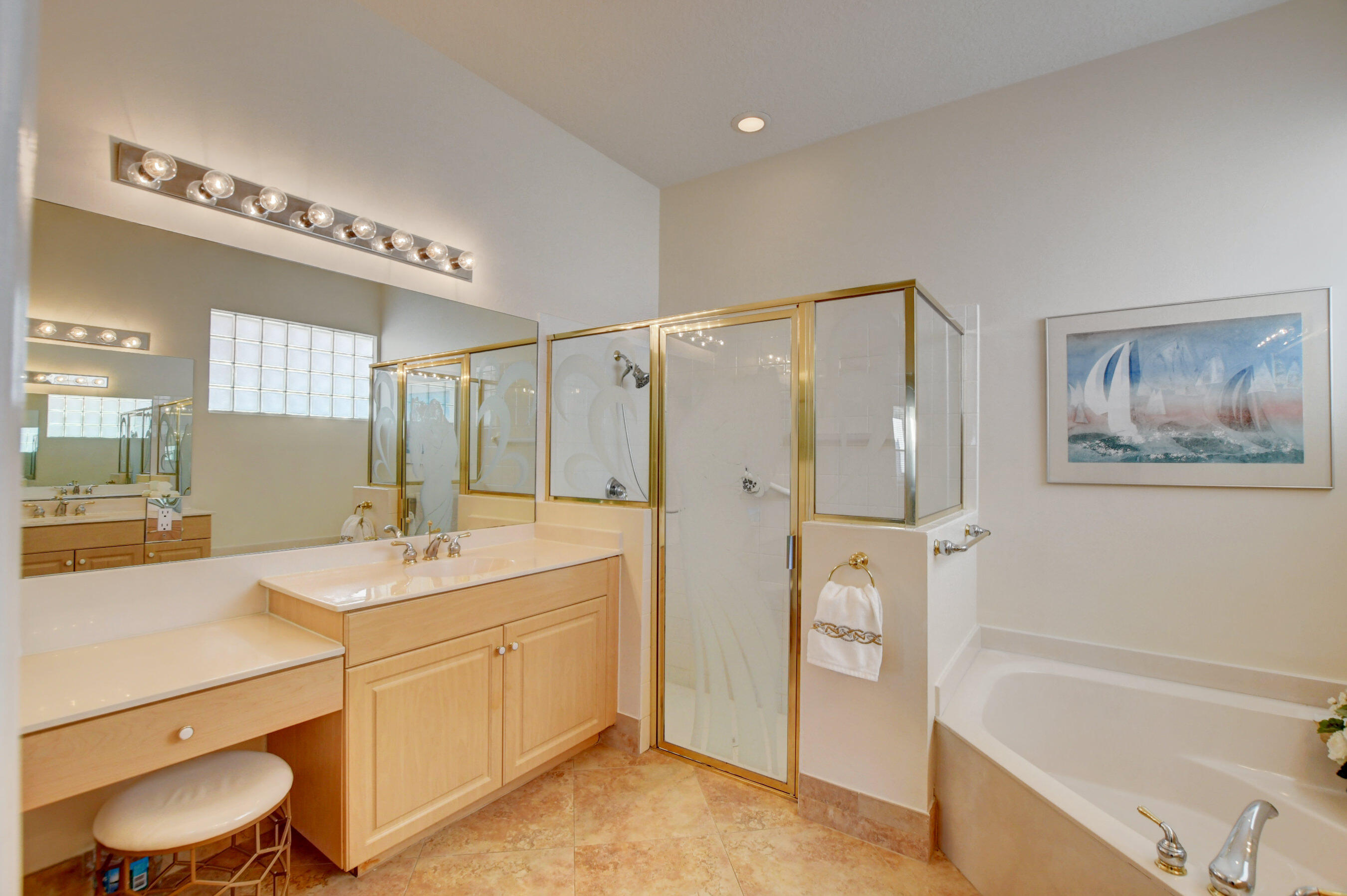 7097 Haviland Circle Boynton Beach, FL 33437 - Photo 17 of 72 a bathroom with a granite countertop sink a toilet a mirror a vanity a bathtub and shower