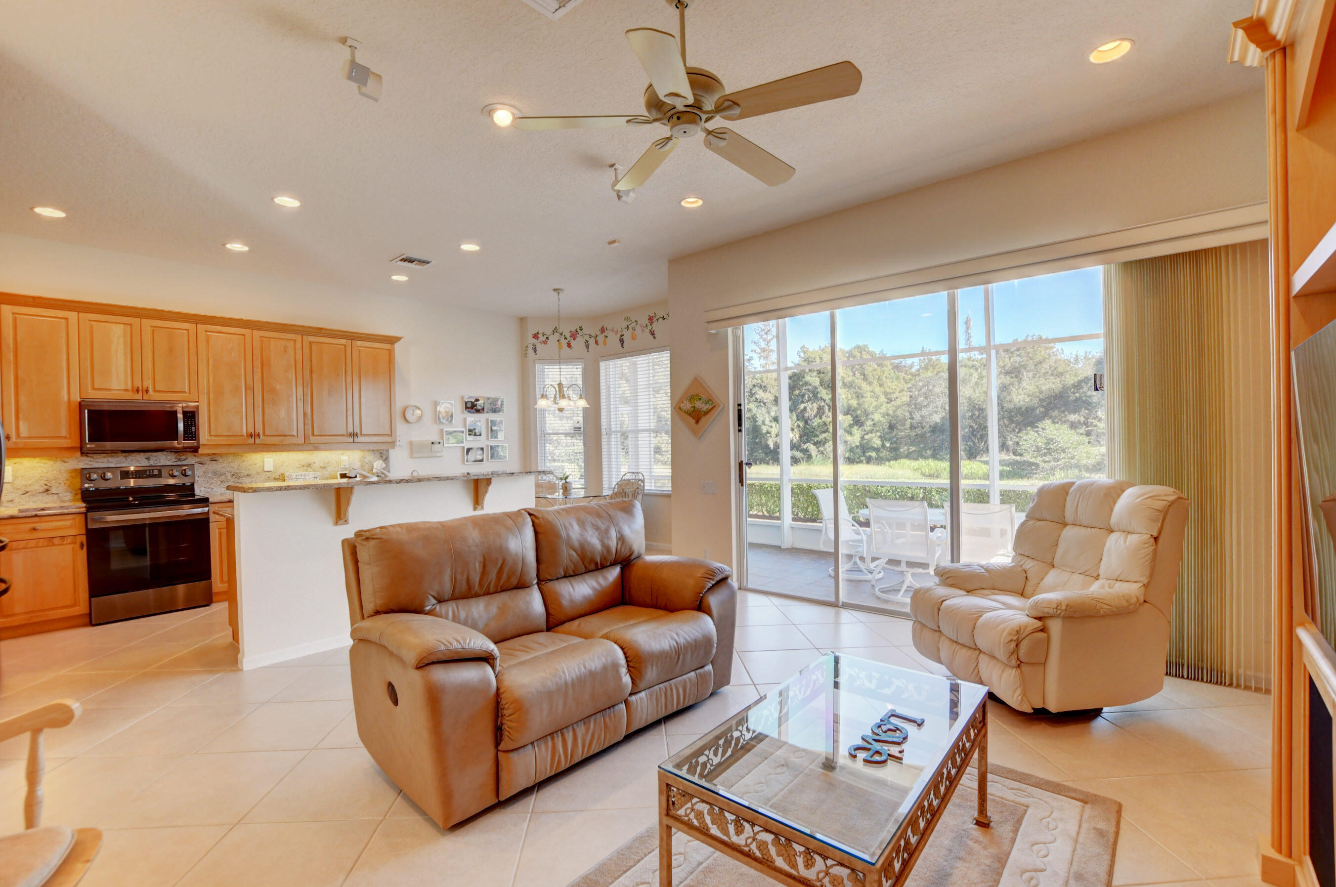 7097 Haviland Circle Boynton Beach, FL 33437 - Photo 31 of 72 a living room with furniture and a large window with kitchen view