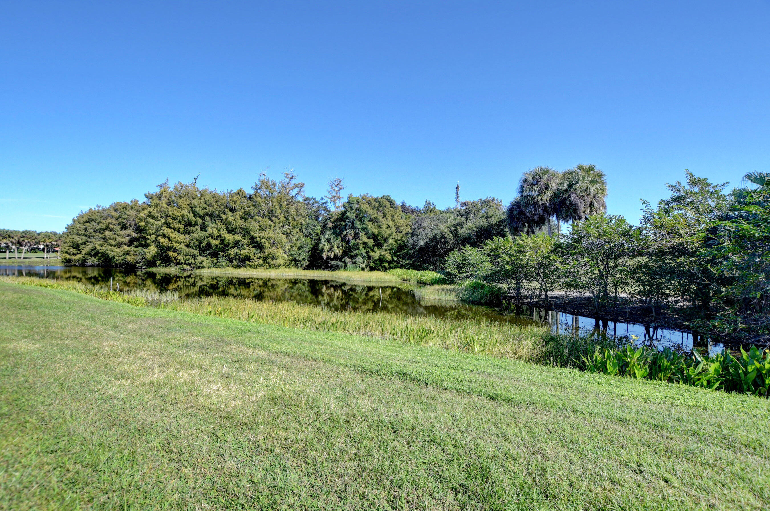 7097 Haviland Circle Boynton Beach, FL 33437 - Photo 39 of 72 a view of a lake with a house in the background