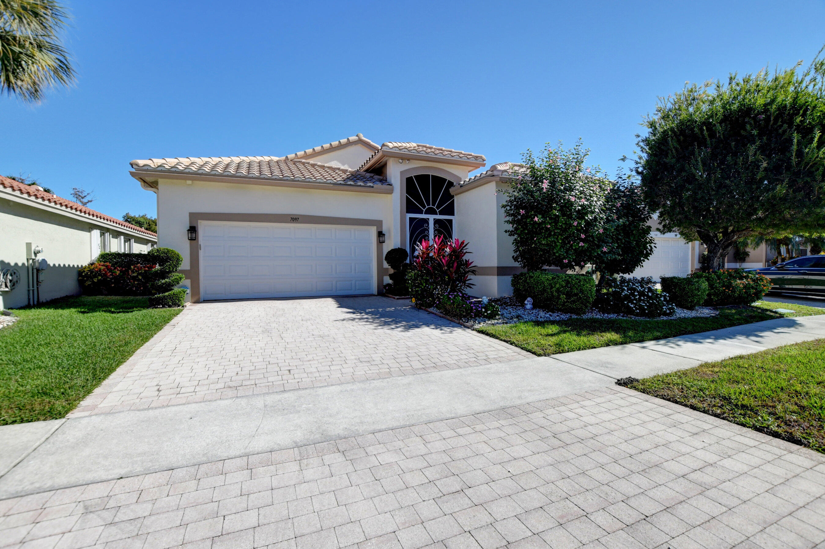 7097 Haviland Circle Boynton Beach, FL 33437 - Photo 43 of 72 front view of a house with a yard and potted plants