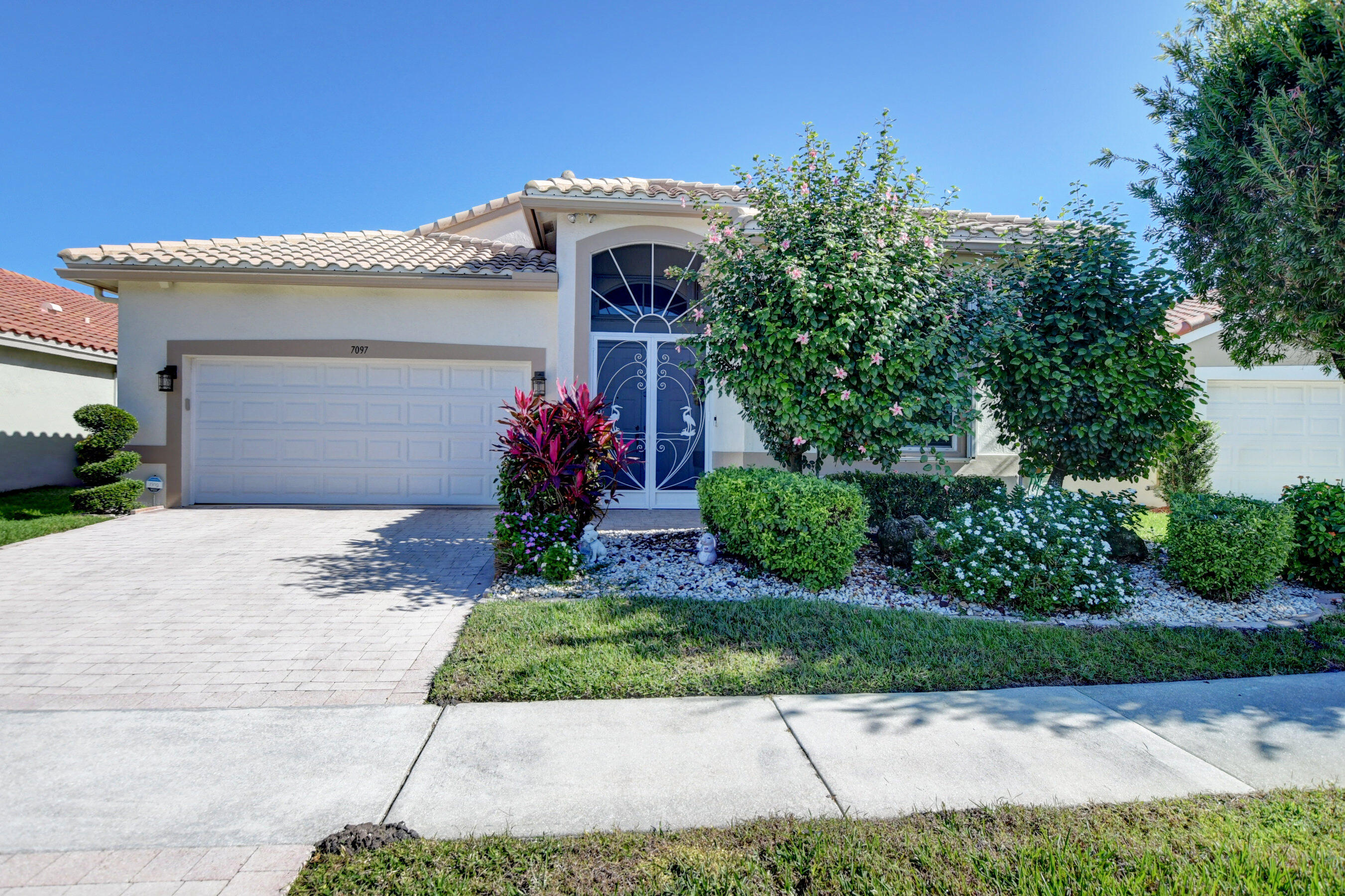7097 Haviland Circle Boynton Beach, FL 33437 - Photo 44 of 72 a front view of a house with garden