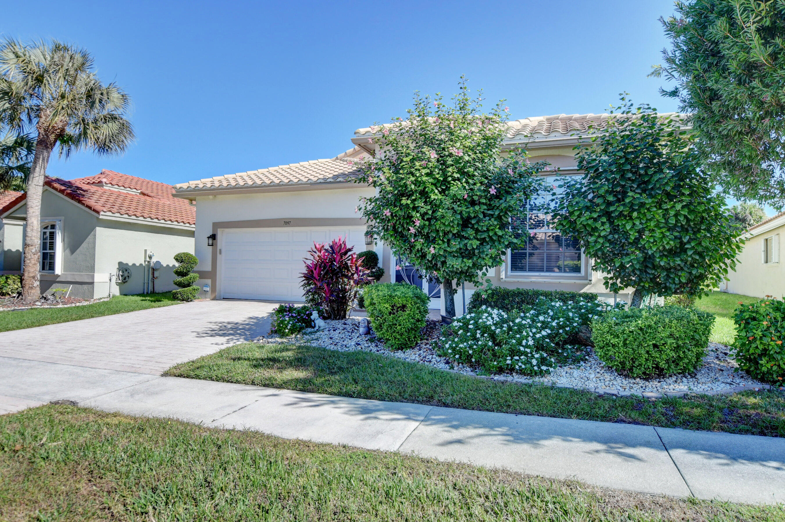 7097 Haviland Circle Boynton Beach, FL 33437 - Photo 45 of 72 a view of a house with a yard and potted plants