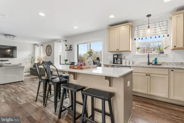 a kitchen with white cabinets and chairs
