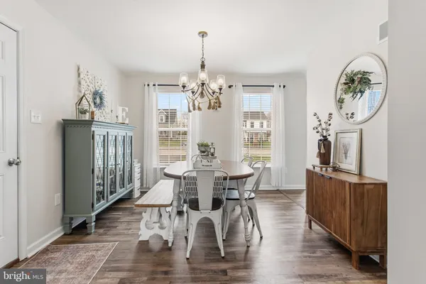 a view of a dining room with furniture a chandelier and wooden floor