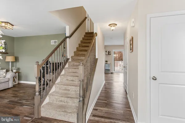 a view of a hallway with wooden floor and stairs