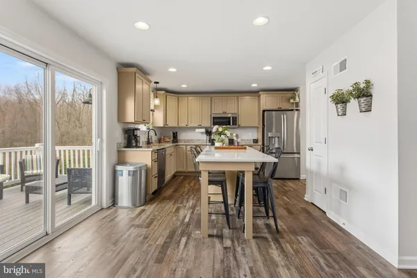 a kitchen with a table chairs refrigerator and cabinets