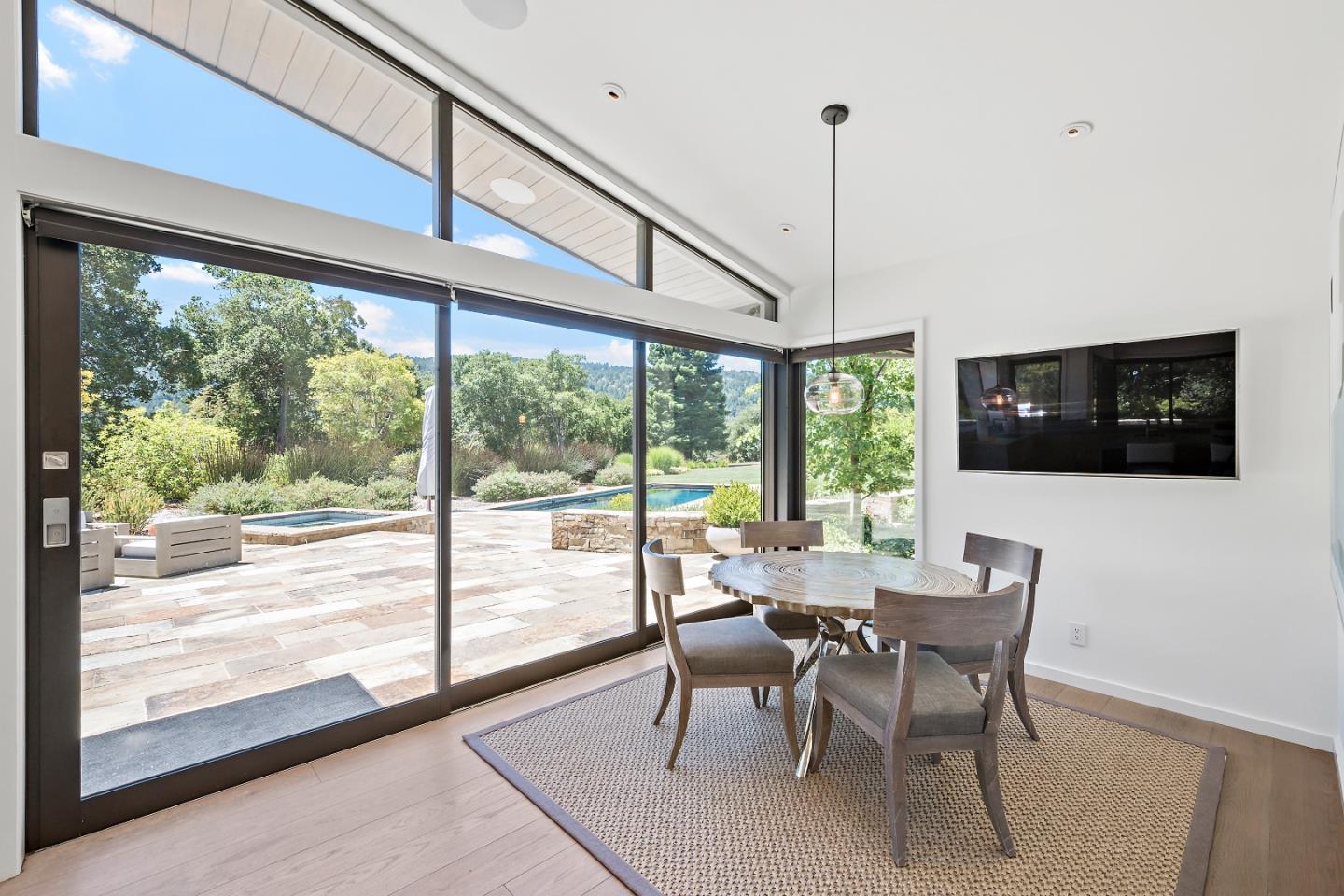396 Raymundo Drive Woodside, CA 94062 - Photo 11 of 58 a view of a dining room with furniture large windows and wooden floor
