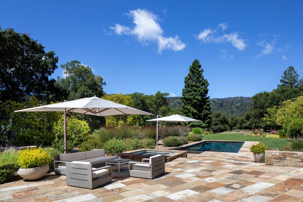 396 Raymundo Drive Woodside, CA 94062 - Photo 18 of 58 a view of a patio with table and chairs under an umbrella