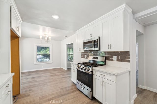 a kitchen with stainless steel appliances a stove microwave and sink