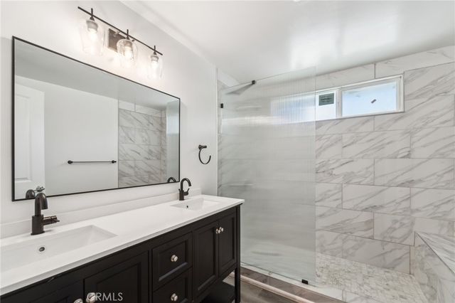 a bathroom with a double vanity sink mirror and shower