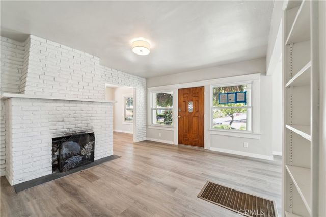 an empty room with windows and fireplace