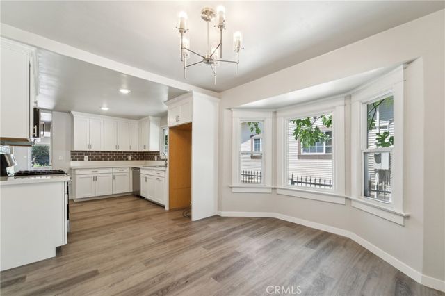 a kitchen with granite countertop a stove a sink dishwasher and a refrigerator with wooden floor