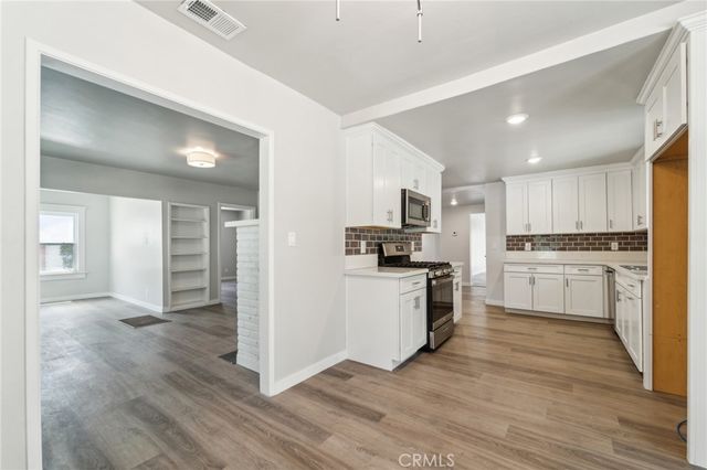 a kitchen with white cabinets and stainless steel appliances