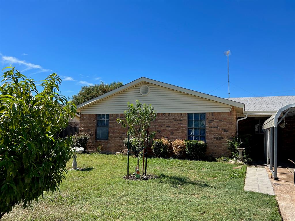 a view of a house with a yard and potted plants