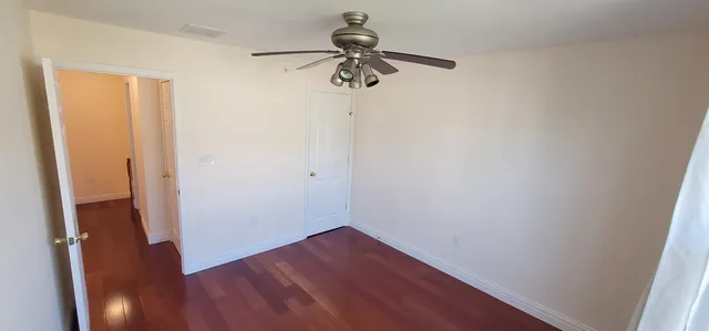 a view of empty room with wooden floor