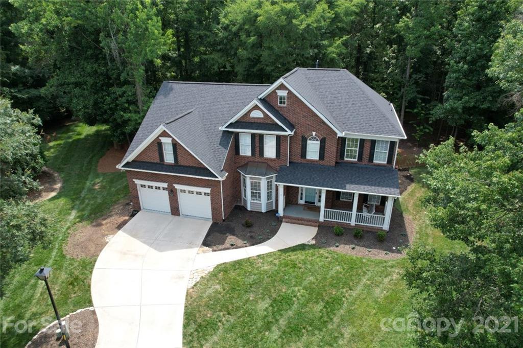 an aerial view of a house with yard porch and green space