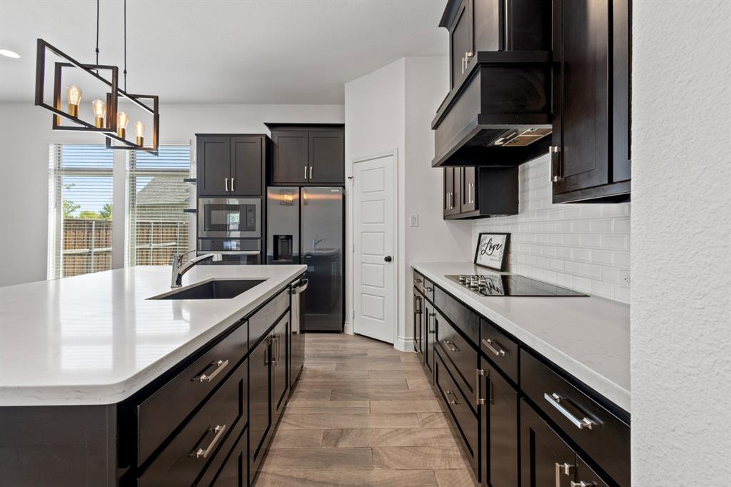 960 Knoxbridge Road Forney, TX 75126 - Photo 6 of 22 Modern kitchen featuring dark cabinetry, light countertops, and wood-finish flooring