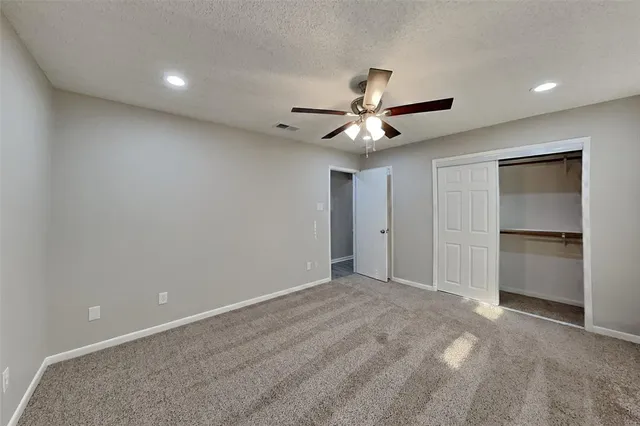 a view of an empty room with a ceiling fan