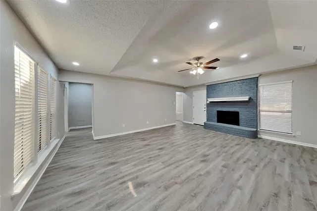 an empty room with wooden floor and a fireplace