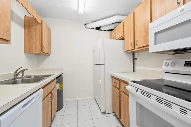 a kitchen with stainless steel appliances granite countertop a sink and a white cabinets