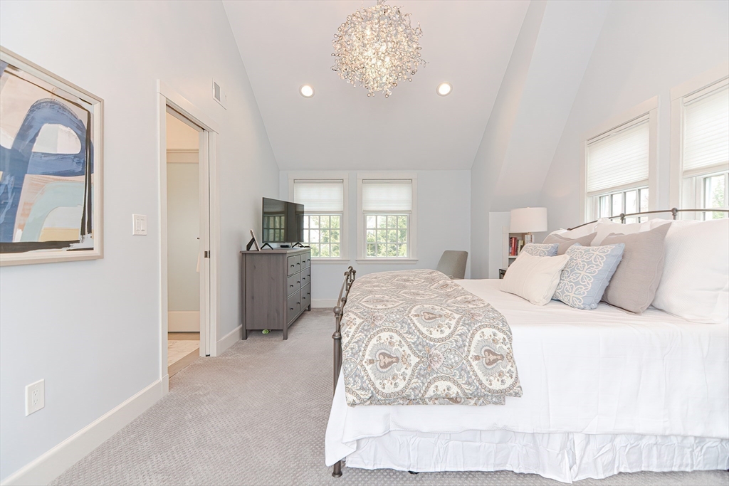 24 Standish Road Wellesley, MA 02481 - Photo 25 of 42 a spacious bedroom with a bed and a chandelier