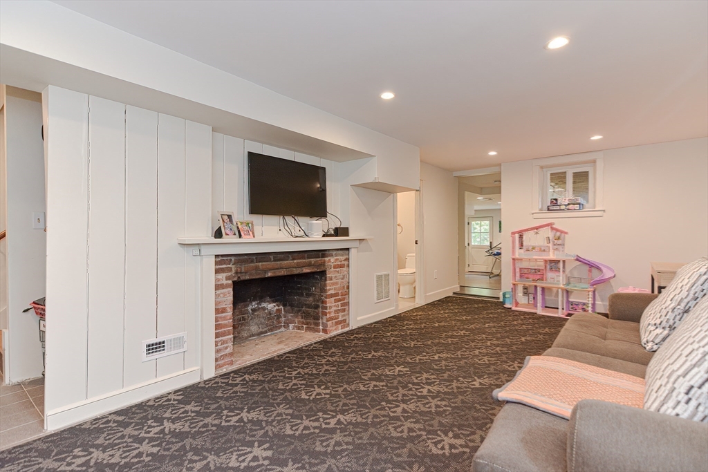 24 Standish Road Wellesley, MA 02481 - Photo 33 of 42 a living room with furniture a flat screen tv and a fireplace