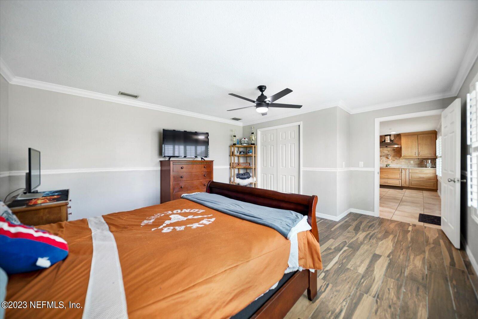 988 Shockney Drive Ormond Beach, FL 32174 - Photo 13 of 46 a bedroom with a bed and a chandelier