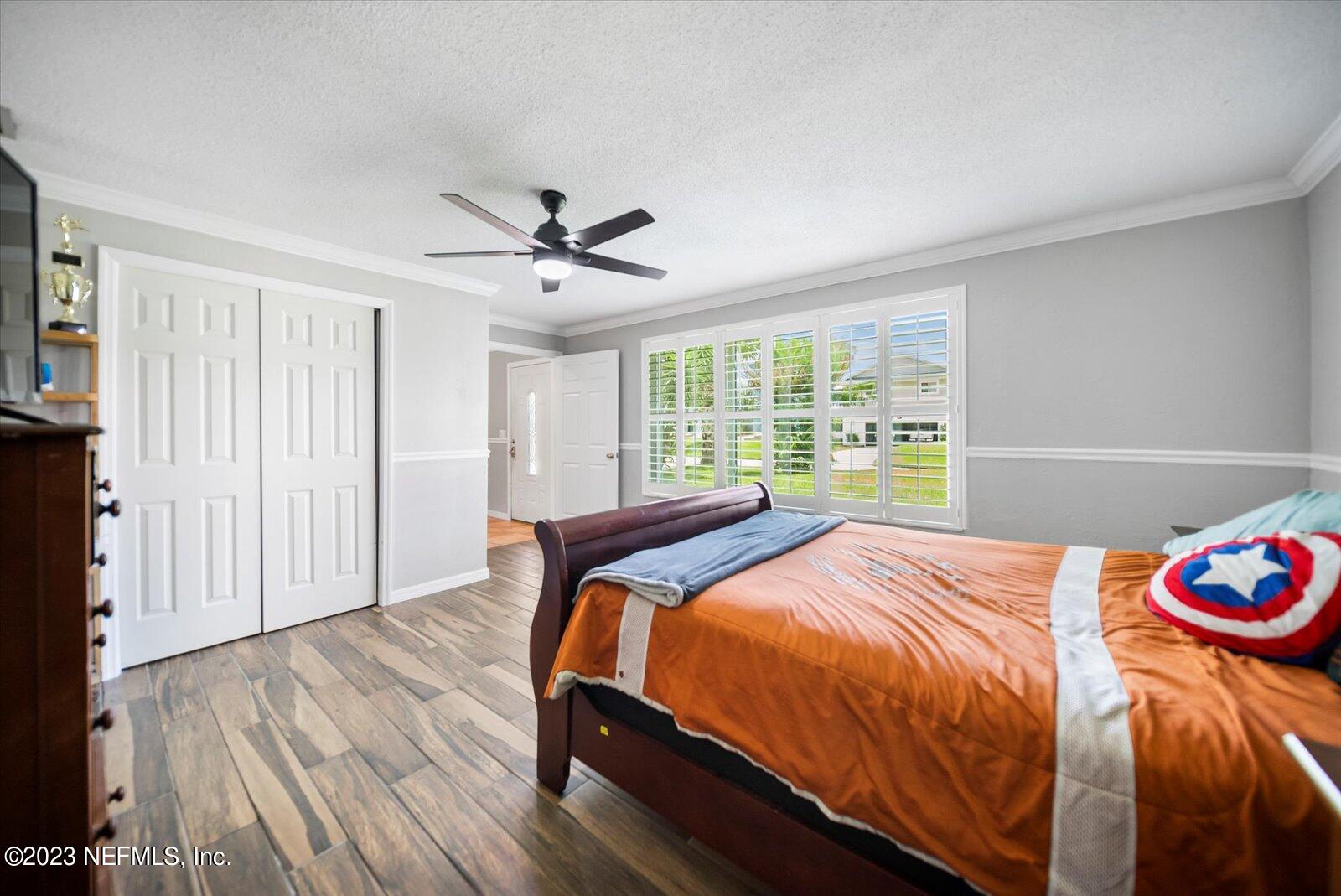 988 Shockney Drive Ormond Beach, FL 32174 - Photo 15 of 46 a bedroom with a bed and a chandelier