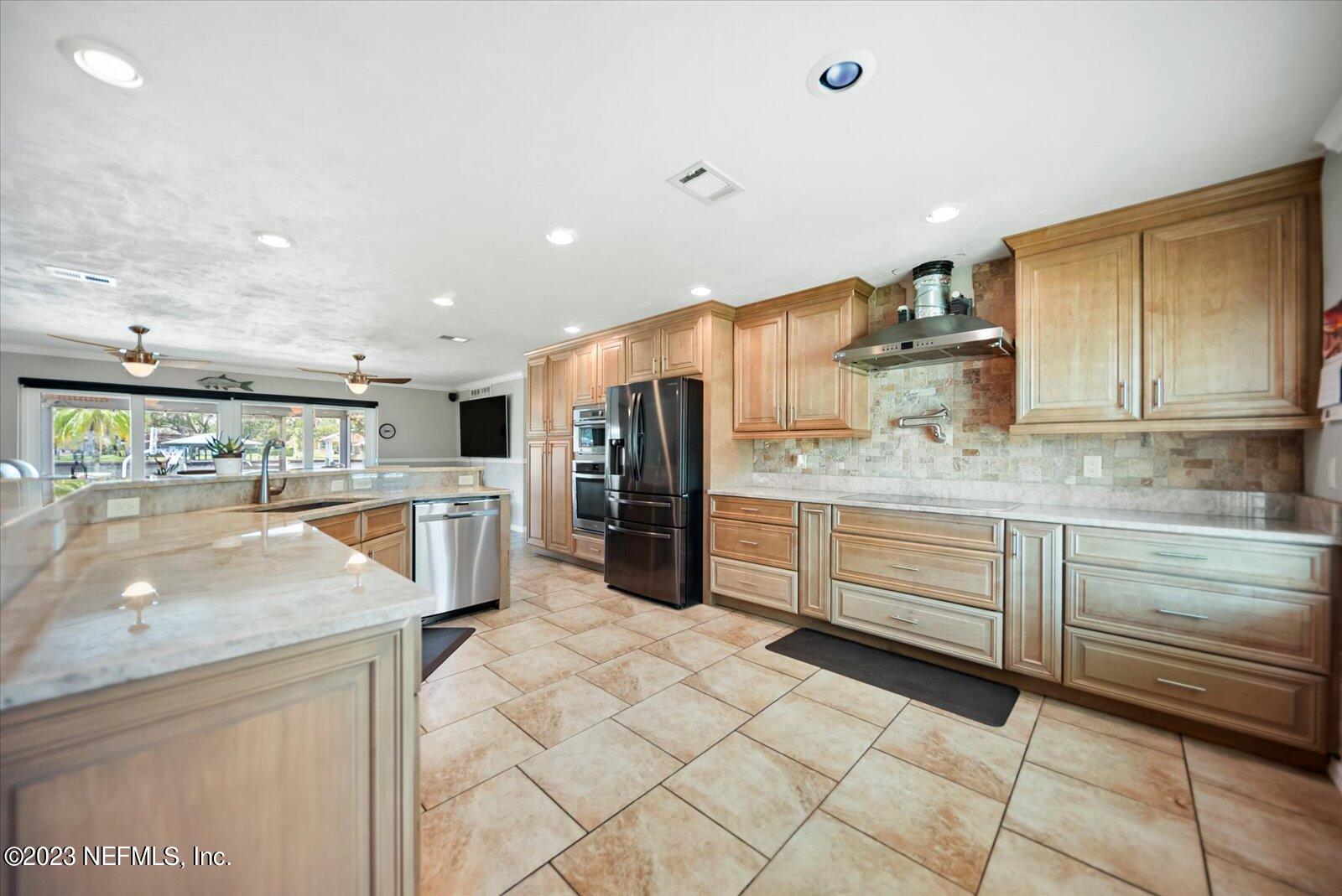 988 Shockney Drive Ormond Beach, FL 32174 - Photo 19 of 46 a kitchen with stainless steel appliances granite countertop a sink and cabinets
