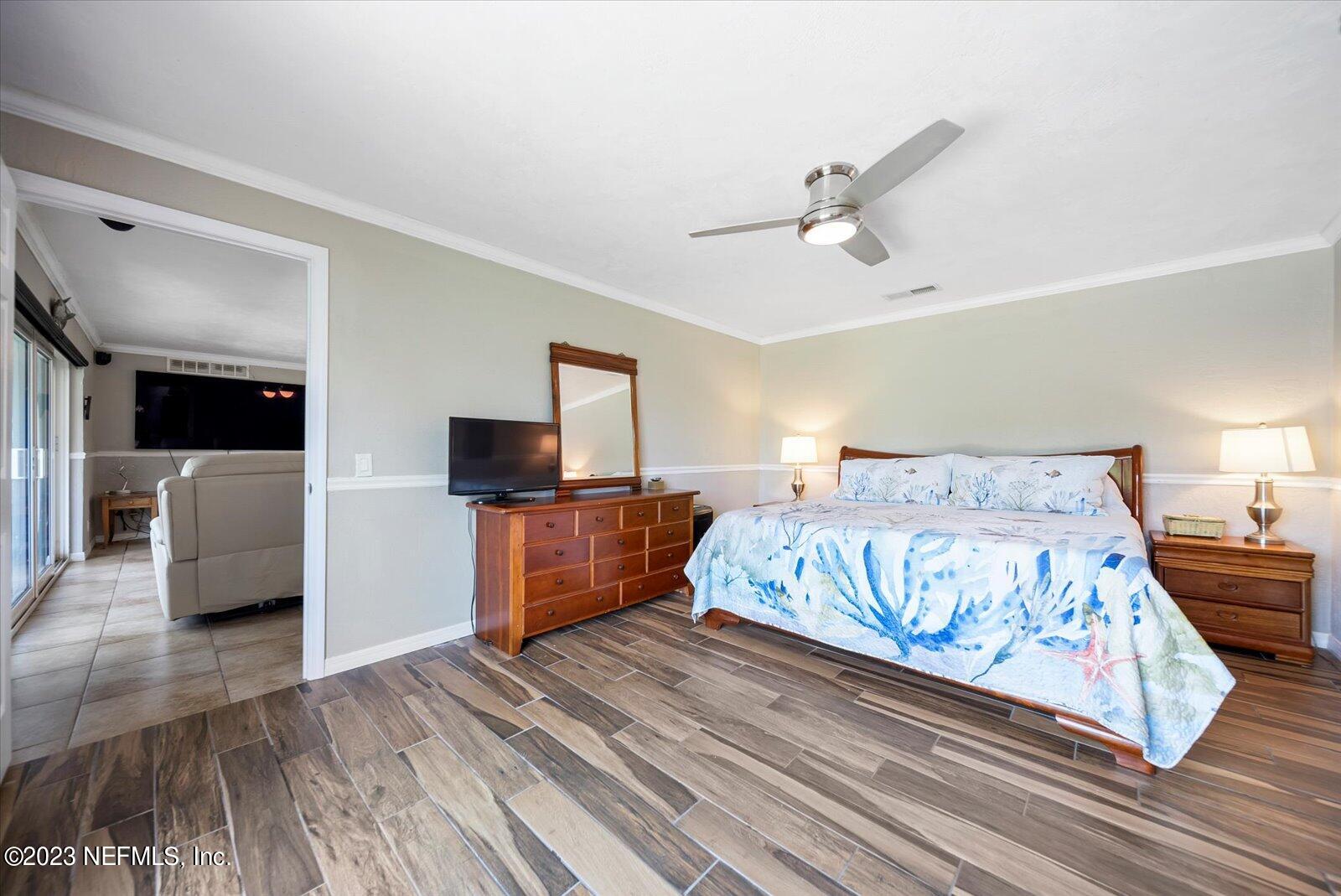988 Shockney Drive Ormond Beach, FL 32174 - Photo 29 of 46 a bedroom with a large bed a flat tv screen and dresser