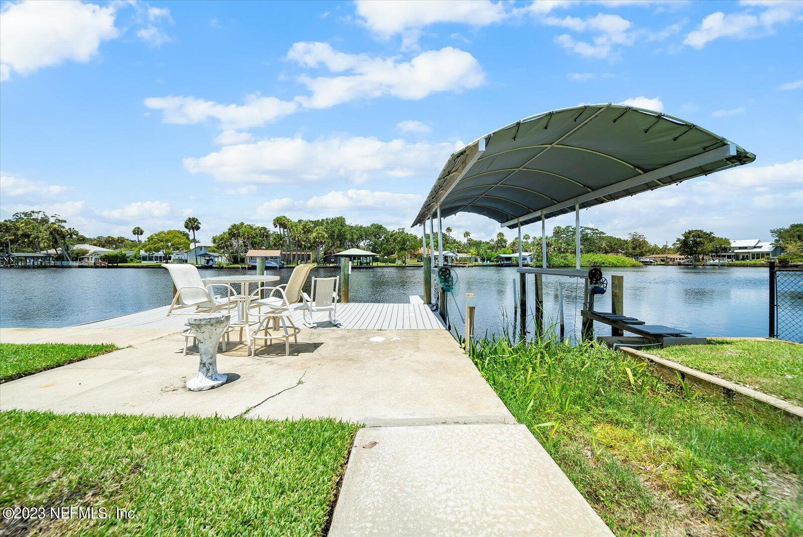 988 Shockney Drive Ormond Beach, FL 32174 - Photo 40 of 46 a view of a patio with a table and chairs under an umbrella