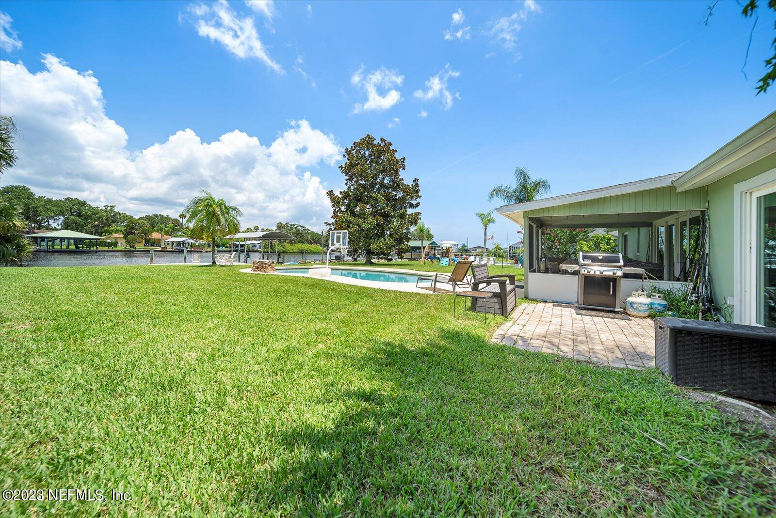 988 Shockney Drive Ormond Beach, FL 32174 - Photo 42 of 46 a view of a patio with table and chairs potted plants and a big yard