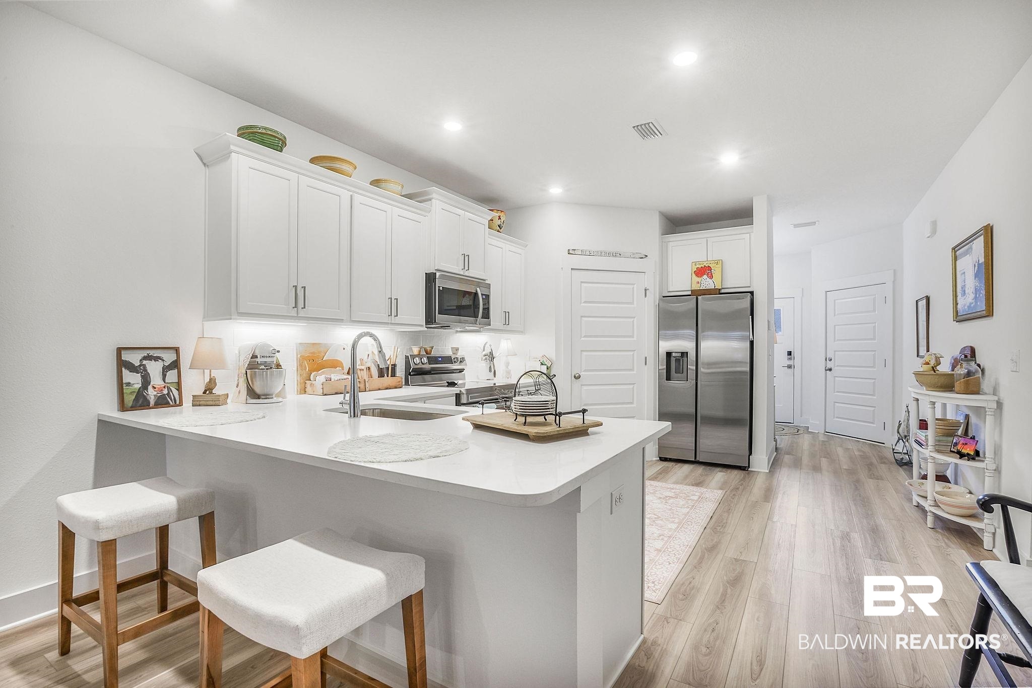 9901 Weller Cove Foley, AL 36535 - Photo 12 of 23 Kitchen with appliances with stainless steel finishes, a peninsula, white cabinetry, light countertops, and recessed lighting