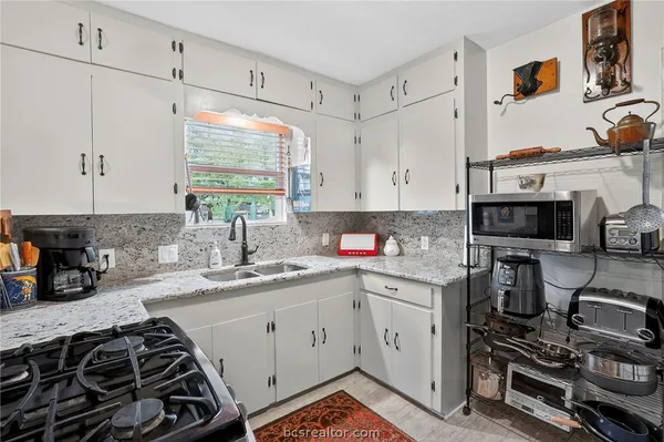a kitchen with appliances a sink and cabinets