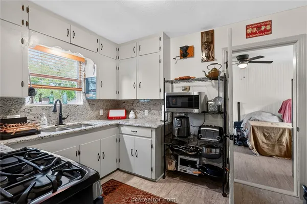 a kitchen with a sink stove and cabinets