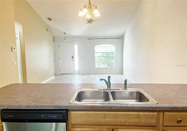 a kitchen with kitchen island granite countertop a sink a counter top space and cabinets