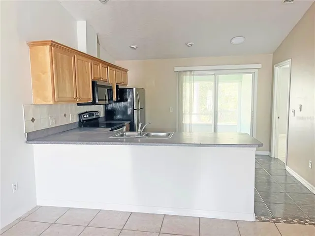 a kitchen with stainless steel appliances a sink a stove and a refrigerator