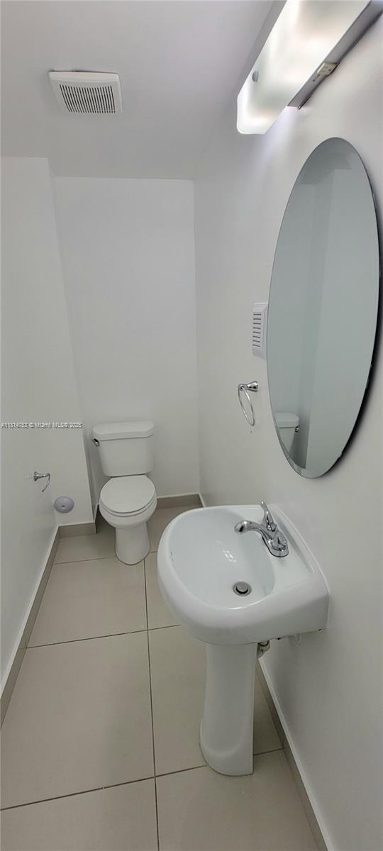 14004 Southwest 259th Street, Unit 14004 Homestead, FL 33032 - Photo 13 of 38 a bathroom with a sink mirror and toilet