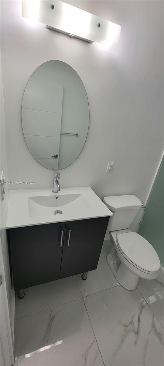 14004 Southwest 259th Street, Unit 14004 Homestead, FL 33032 - Photo 20 of 38 a bathroom with a toilet a sink and mirror