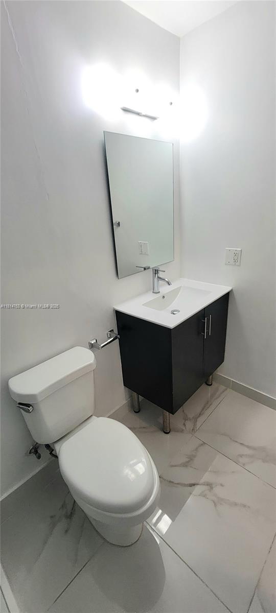 14004 Southwest 259th Street, Unit 14004 Homestead, FL 33032 - Photo 25 of 38 a bathroom with a sink mirror vanity and toilet