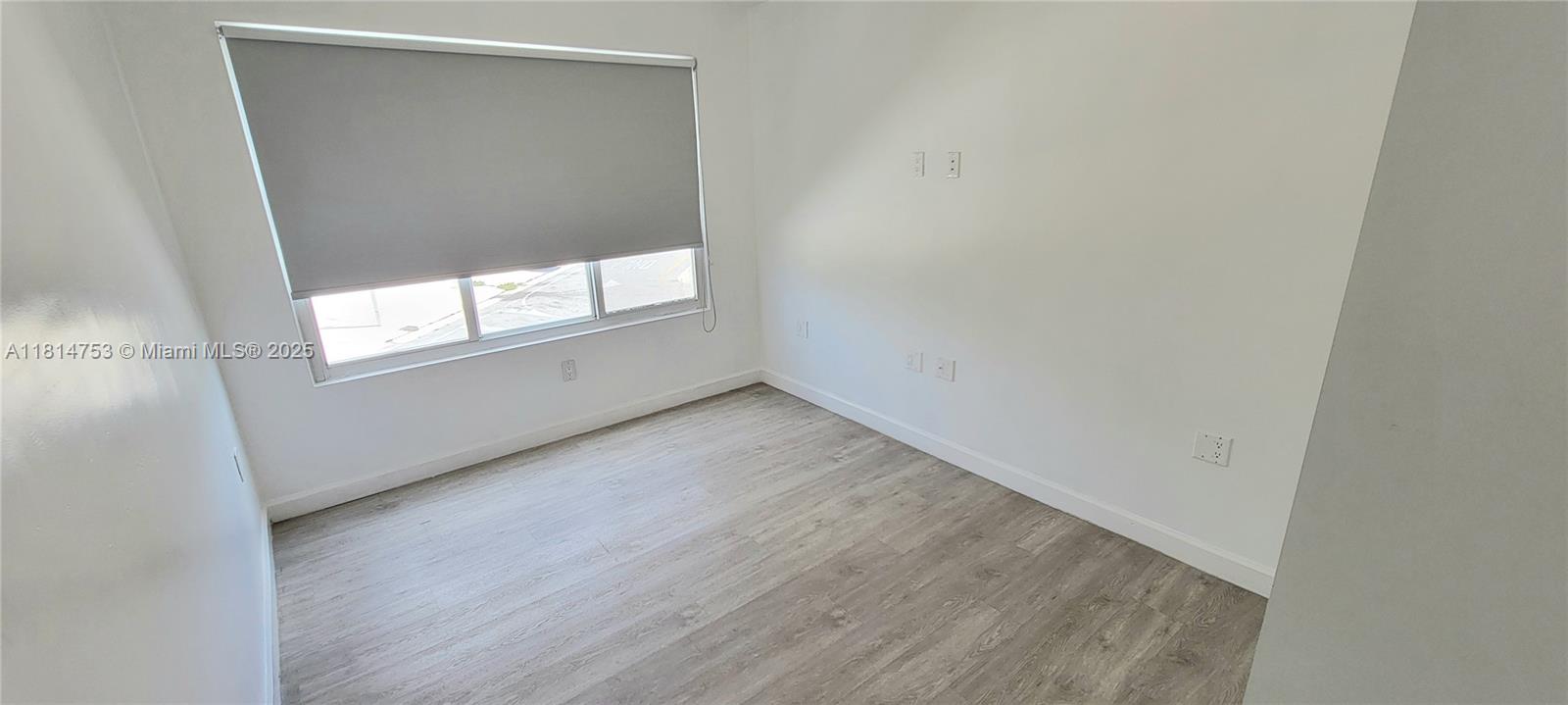 14004 Southwest 259th Street, Unit 14004 Homestead, FL 33032 - Photo 35 of 38 an empty room with wooden floor and windows