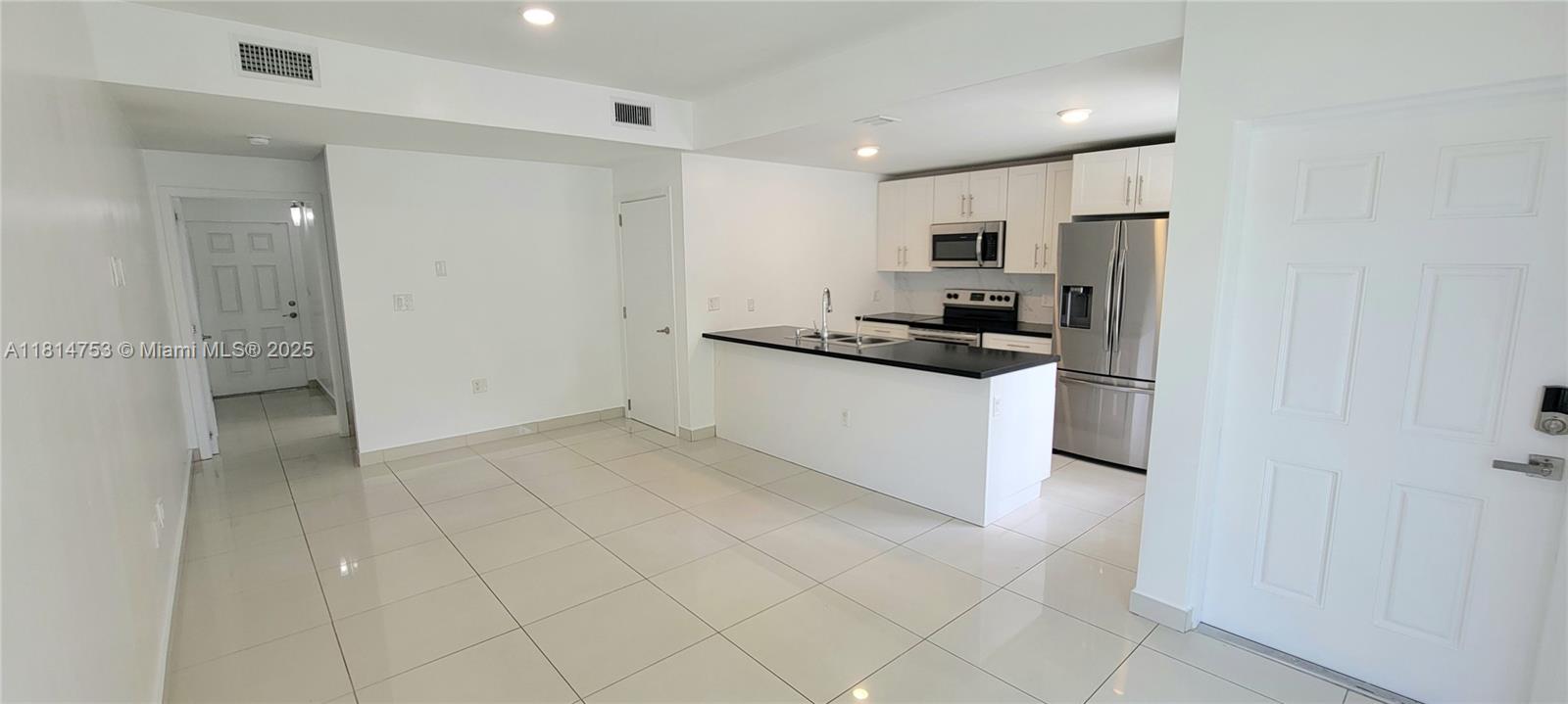 14004 Southwest 259th Street, Unit 14004 Homestead, FL 33032 - Photo 4 of 38 a kitchen with stainless steel appliances a refrigerator stove and sink