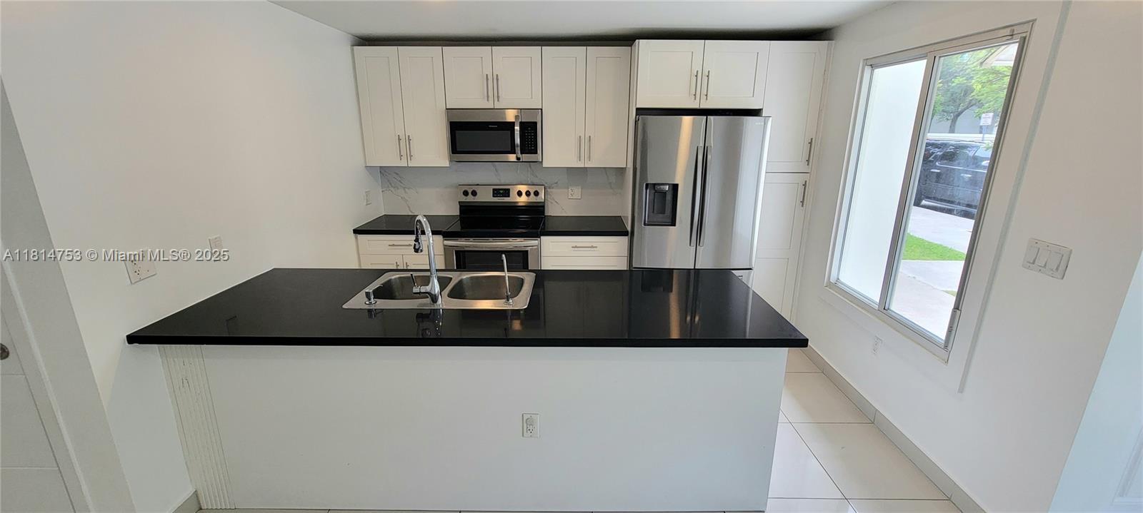 14004 Southwest 259th Street, Unit 14004 Homestead, FL 33032 - Photo 6 of 38 a kitchen with a refrigerator and a stove top oven