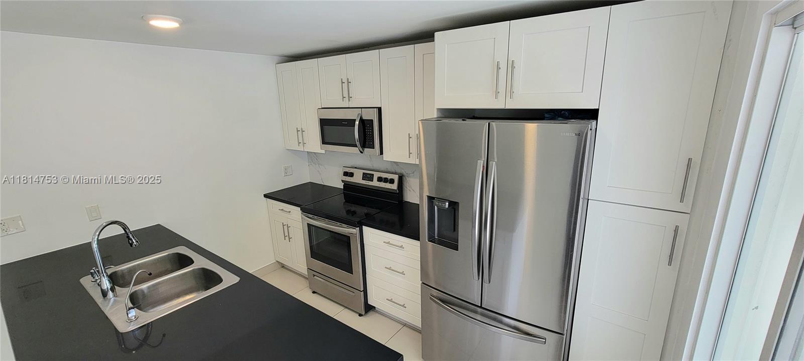 14004 Southwest 259th Street, Unit 14004 Homestead, FL 33032 - Photo 8 of 38 a white refrigerator freezer and a stove sitting inside of a kitchen