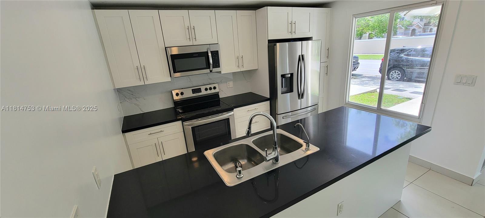 14004 Southwest 259th Street, Unit 14004 Homestead, FL 33032 - Photo 9 of 38 a view of kitchen with wooden floor electronic appliances and windows